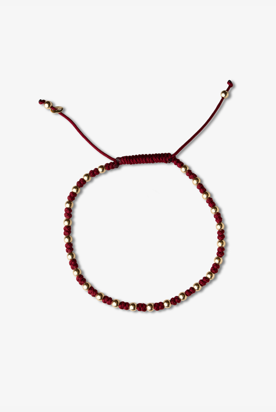Pulseira com bolinhas em ouro amarelo e algodão bordeaux. 